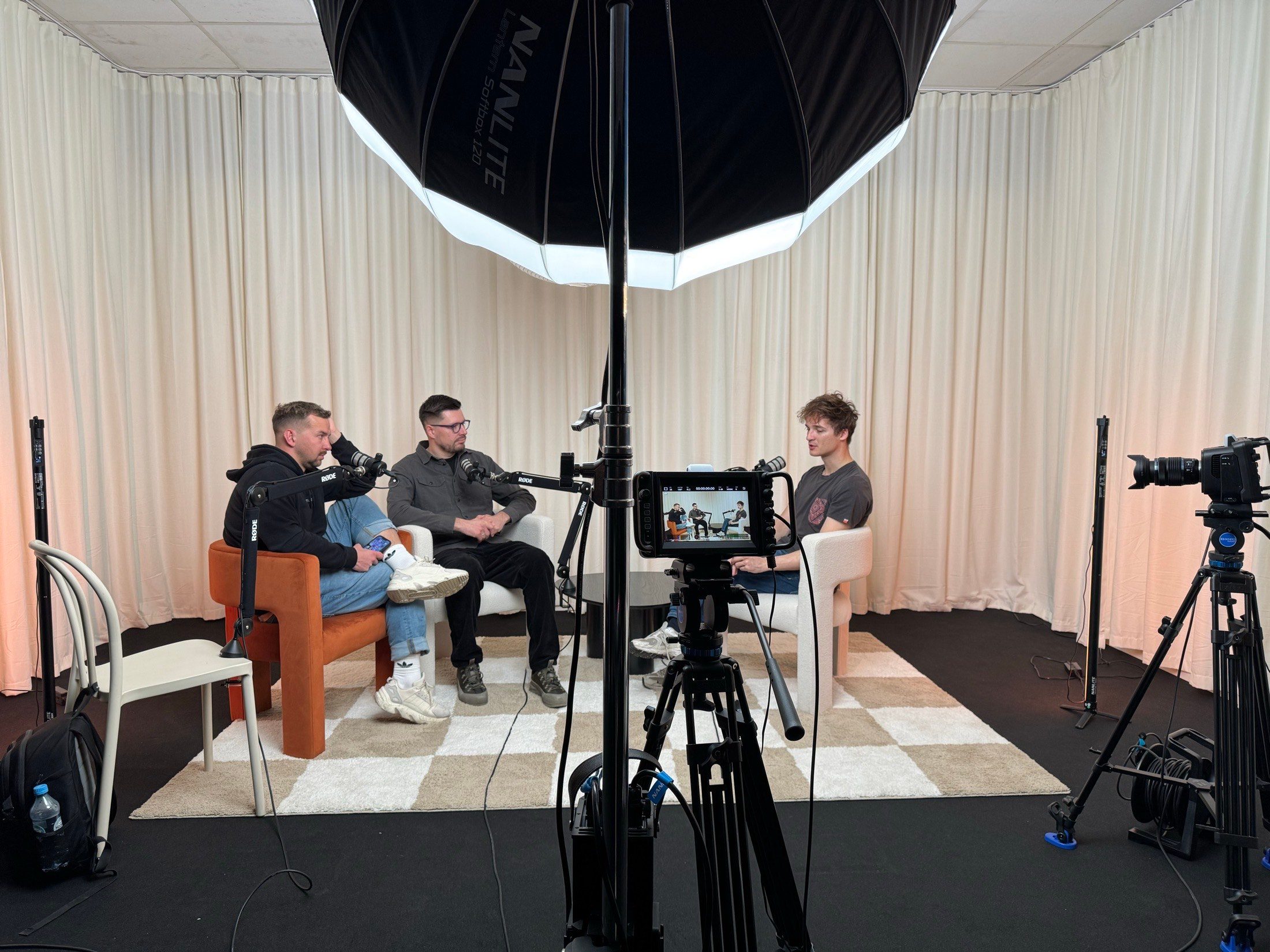 Plan podcastu i wywiadu dla dwóch gości na podłodze w szachownicę, przy dwóch operatorach.