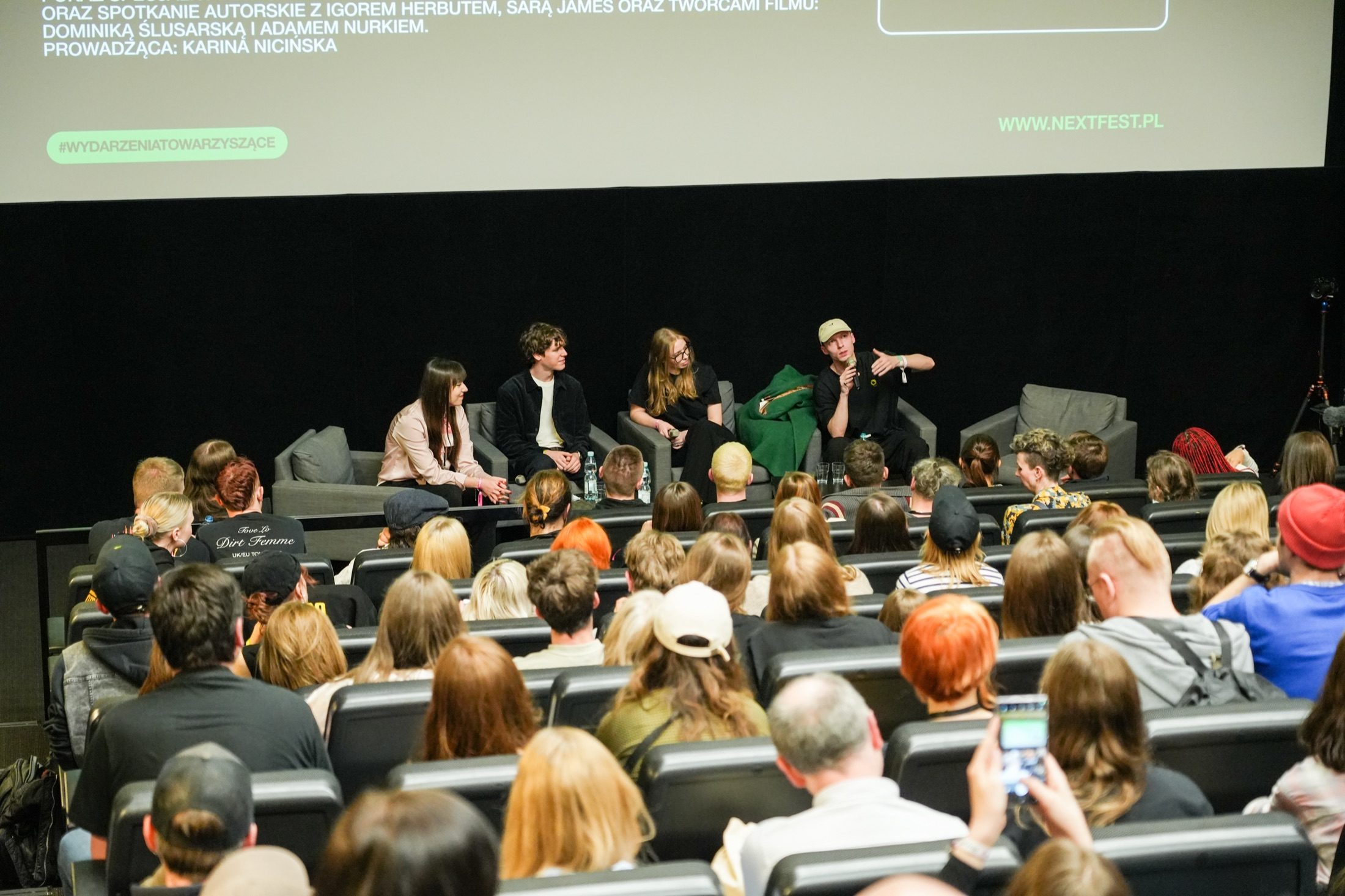 Vier Personen auf einem Next-Fest-Q&A-Panel auf der Bühne vor sitzendem Publikum.