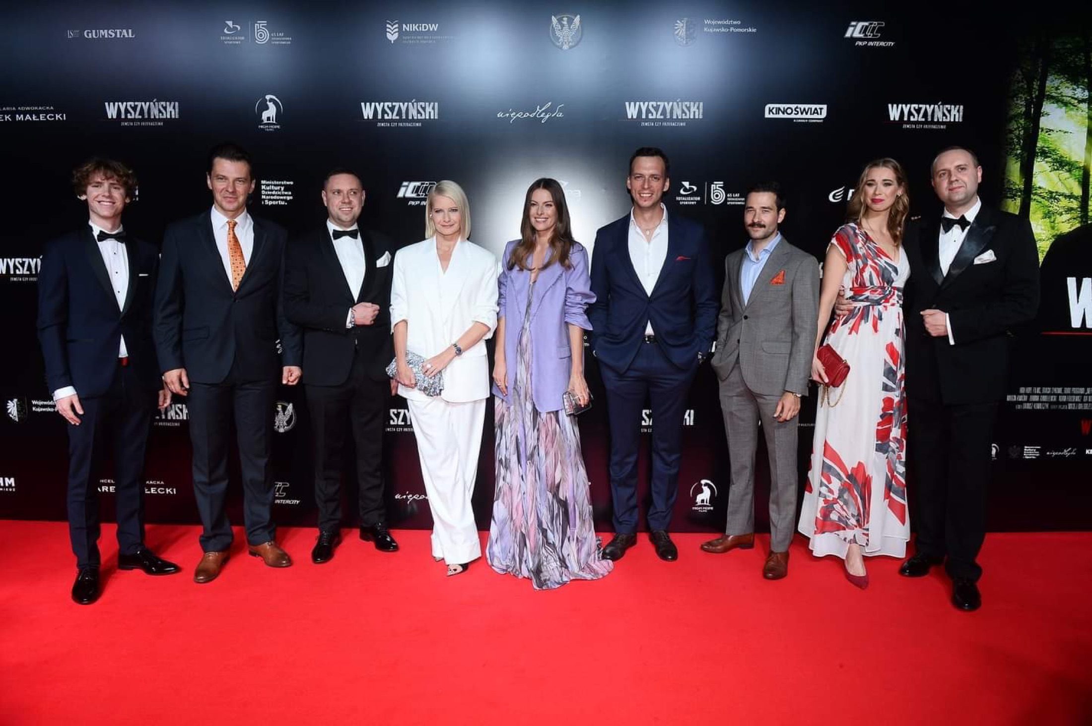 Neun Personen in Abendgarderobe auf dem roten Teppich der Wyszyński-Spielfilmpremiere.