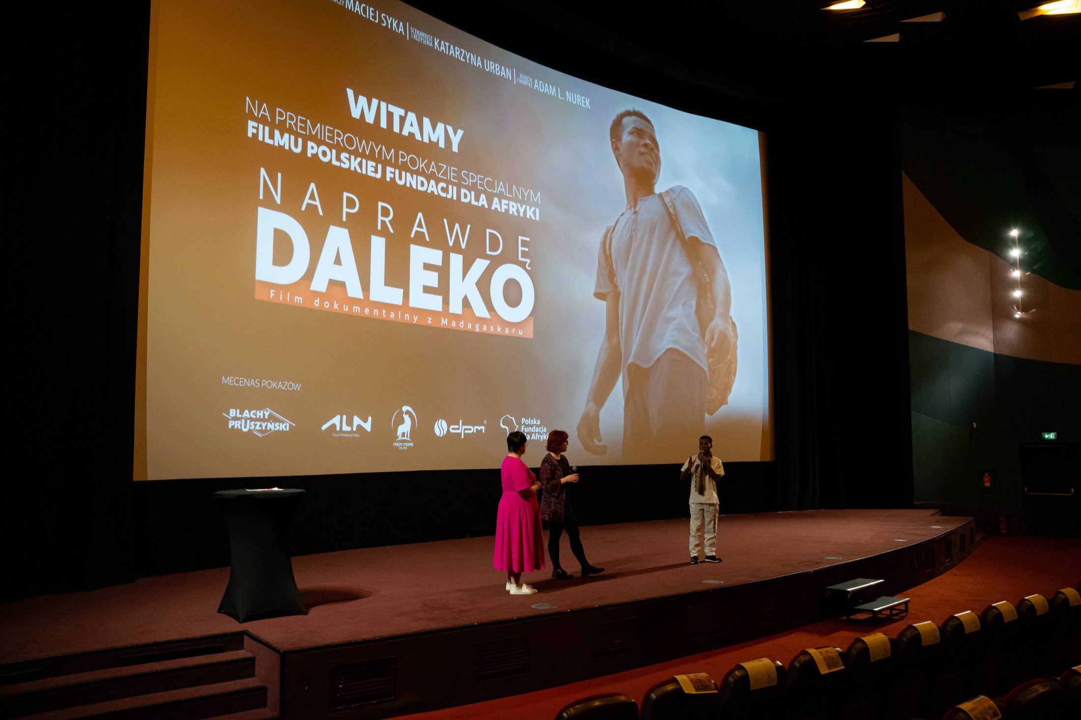 Ein Q&A auf der Bühne — der Protagonist und Moderatoren, dahinter der projizierte Filmtitel und Sponsorenlogos.